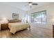 Bright bedroom with wood-framed bed, ceiling fan, and a window overlooking the pool area at 330 W Locust Dr, Chandler, AZ 85248