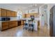 Spacious kitchen with oak cabinets, a black dishwasher, an island with bar seating and track lighting at 330 W Locust Dr, Chandler, AZ 85248