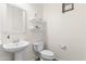 This half bath features a pedestal sink, toilet, floating shelves, and decorative mirror at 3551 E Shannon St, Gilbert, AZ 85295