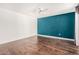 Bedroom featuring hardwood floors, ceiling fan, and accent wall at 3927 W Phelps Rd, Phoenix, AZ 85053