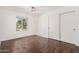 Bedroom featuring hardwood floors, closet with sliding doors, and window with a view at 3927 W Phelps Rd, Phoenix, AZ 85053