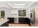 Well-lit kitchen with black and white cabinetry, a large window, and stainless steel appliances at 3927 W Phelps Rd, Phoenix, AZ 85053