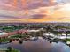 Scenic aerial view of community clubhouse, pool, and lake at sunset at 42024 W Rosewood Ln, Maricopa, AZ 85138