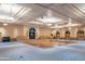 Expansive ballroom featuring a wooden dance floor, raised stage, and elegant lighting fixtures at 42024 W Rosewood Ln, Maricopa, AZ 85138