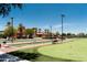 Outdoor view of lush community greens, featuring a bocce ball court, landscaping, and walkway at 42024 W Rosewood Ln, Maricopa, AZ 85138