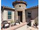 Exterior entrance featuring a stone turret, landscaped walkway, and comfortable seating at 42024 W Rosewood Ln, Maricopa, AZ 85138