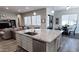 Kitchen island with granite counters, stainless steel appliances, and open layout to dining and living areas at 42024 W Rosewood Ln, Maricopa, AZ 85138