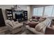 Comfortable living room featuring plush furniture, a modern entertainment center, and neutral decor at 42024 W Rosewood Ln, Maricopa, AZ 85138