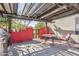 Charming patio area with a grill, red accent wall, and pergola for shade at 4309 S Priceless View Dr, Gold Canyon, AZ 85118