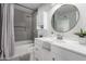 Stylish bathroom with tiled shower, sleek fixtures, and round mirror at 4341 W Ocotillo Rd, Glendale, AZ 85301