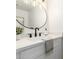 Modern bathroom vanity with matte black faucet, circular mirror, and white countertops at 4341 W Ocotillo Rd, Glendale, AZ 85301