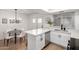 Bright open kitchen with a dining area, white cabinetry, stainless appliances, and quartz counters at 4341 W Ocotillo Rd, Glendale, AZ 85301