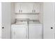 Efficient laundry space with white washer, dryer, and overhead cabinets at 4341 W Ocotillo Rd, Glendale, AZ 85301