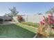 Lush backyard with well-maintained artificial grass, attractive shrubs, and a block wall at 4428 W Mission Ln, Glendale, AZ 85302