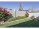 A well-kept backyard with artificial grass, block wall, storage shed, and attractive flowering shrubs at 4428 W Mission Ln, Glendale, AZ 85302