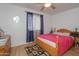 Bright bedroom with wood-look floors, ceiling fan, window with curtains, and bed at 4428 W Mission Ln, Glendale, AZ 85302