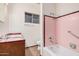 A full bath features a tub with a pink tile surround and a single sink vanity with a brown tile backsplash at 4502 N 2Nd Dr, Phoenix, AZ 85013