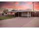 The exterior of this brick home with a covered carport and extended driveway is nicely landscaped at 4502 N 2Nd Dr, Phoenix, AZ 85013