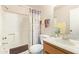 Well-lit bathroom featuring a shower-tub combo with decorative curtain, vanity, and fresh floral accents at 455 S Delaware Dr # 106, Apache Junction, AZ 85120