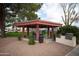 The community red roofed gazebo with chairs, table and nearby barbeque at 455 S Delaware Dr # 106, Apache Junction, AZ 85120