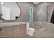 Contemporary bathroom featuring a glass shower, tiled walls, and modern vanity with a round mirror at 4704 N 40Th Pl, Phoenix, AZ 85018