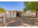 Exterior shot of a barn with a metal roof, adjacent pens, and tree lined perimeter at 5226 W Tierra Buena Ln, Glendale, AZ 85306