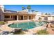 A pristine backyard pool featuring rock features, cleaning system, and exterior kitchen at 5345 E Mercer Ln, Scottsdale, AZ 85254