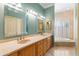 This bathroom features double sinks, granite countertops, mirrors and modern lighting, with a tub near shuttered windows at 5345 E Mercer Ln, Scottsdale, AZ 85254