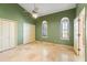 This bedroom features a ceiling fan, two arched windows, a door to another room and a closet at 5345 E Mercer Ln, Scottsdale, AZ 85254