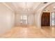 Elegant dining room with travertine floors, chandelier, and arched entry with a decorative glass window at 5345 E Mercer Ln, Scottsdale, AZ 85254