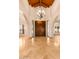 Grand foyer with a chandelier, arched windows, and marble floors. Large wooden double doors at 5345 E Mercer Ln, Scottsdale, AZ 85254