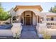 Arched front entrance with double doors and decorative columns. A stone walkway guides to the property at 5345 E Mercer Ln, Scottsdale, AZ 85254