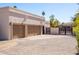 A three-car garage offers plenty of parking and storage on a property featuring desert landscaping at 5345 E Mercer Ln, Scottsdale, AZ 85254