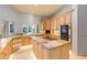 Well-lit kitchen featuring granite countertops, wood cabinets, stainless steel appliances, and an island cooktop at 5345 E Mercer Ln, Scottsdale, AZ 85254