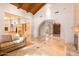 Living room featuring a stone fireplace, travertine floors, and a vaulted wood ceiling at 5345 E Mercer Ln, Scottsdale, AZ 85254