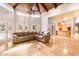 Open living room with travertine floors, a vaulted wood beam ceiling, and view to the kitchen at 5345 E Mercer Ln, Scottsdale, AZ 85254