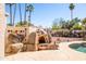 Poolside pizza oven and outdoor eating area at 5345 E Mercer Ln, Scottsdale, AZ 85254