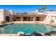 A backyard pool featuring rock features, submerged cleaning system, and exterior kitchen at 5345 E Mercer Ln, Scottsdale, AZ 85254