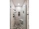 Modern walk-in shower featuring stone flooring, a built-in seat, and stylish matte black fixtures at 5350 E Deer Valley Dr # 2246, Phoenix, AZ 85054