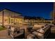 Elegant outdoor seating by the pool with mountain views, adjacent to a modern, glass-walled home at 5910 N 45Th St, Phoenix, AZ 85018