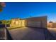 Contemporary home with a clean facade, artificial turf, and well-lit driveway at twilight at 5910 N 45Th St, Phoenix, AZ 85018