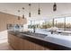 Bright kitchen with island seating, stainless steel appliances, and pendant lighting overlooking the outdoor dining area at 5910 N 45Th St, Phoenix, AZ 85018