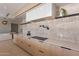 Kitchen area with light wood cabinets, stone backsplash, modern vent hood, and stainless steel appliances at 5910 N 45Th St, Phoenix, AZ 85018