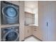 Well-organized laundry room with stacked washer and dryer, ample cabinet space, and a built-in sink at 5910 N 45Th St, Phoenix, AZ 85018