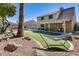 Expansive backyard view features covered patio, artificial grass, pool, and outdoor seating with a hammock at 6938 W Wescott Dr, Glendale, AZ 85308