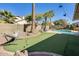 Lush backyard with artificial grass, mature trees, a pool, a hammock, and thoughtfully designed landscaping at 6938 W Wescott Dr, Glendale, AZ 85308