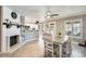 Open-concept dining area with updated lighting, neutral paint, and view of kitchen and fireplace at 6938 W Wescott Dr, Glendale, AZ 85308