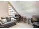 Attic home office featuring a sloped ceiling, a modern desk, and a comfortable gray sofa at 6938 W Wescott Dr, Glendale, AZ 85308