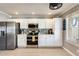 Modern kitchen with stainless steel appliances, white cabinetry, mosaic backsplash, and wood look floors at 6938 W Wescott Dr, Glendale, AZ 85308