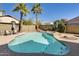 Refreshing pool with a unique rock feature, surrounded by palm trees and desert landscaping for privacy at 6938 W Wescott Dr, Glendale, AZ 85308